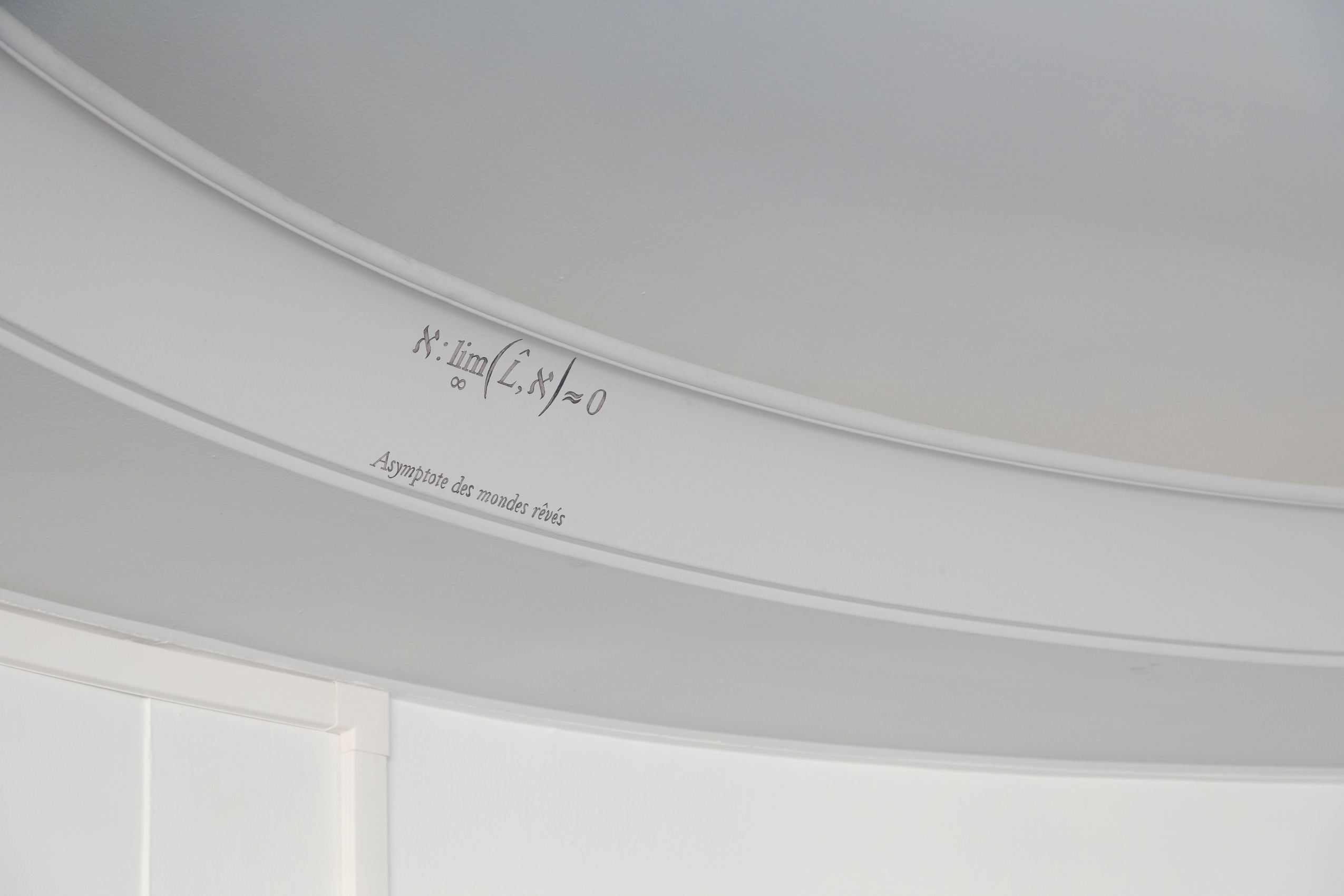Au creux du plafond circulaire du bureau de la Présidence, les moulures accompagnent une inscription mystérieuse : une équation écrite en noir sur le mur blanc.